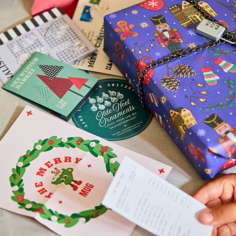Padlock'd Festive: a nutcracker-print wrapped gift with a combination lock, beside The Merry Mug menu, a ticket and a bauble flyer
